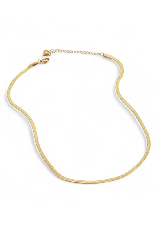 Lady wearing a sleek, minimalist gold necklace with a smooth, curved design, elegant, modern, and perfect for layering or solo statement styling.