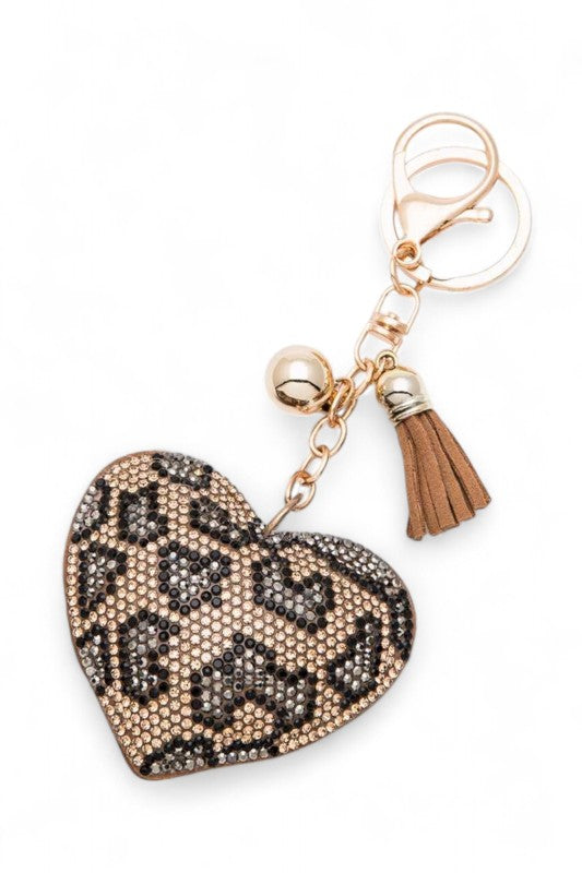 Heart-shaped leopard print keychain with beaded detailing, gold chain, brown tassel, and metallic charm, bold, stylish, and perfect for accessorizing bags or keys.