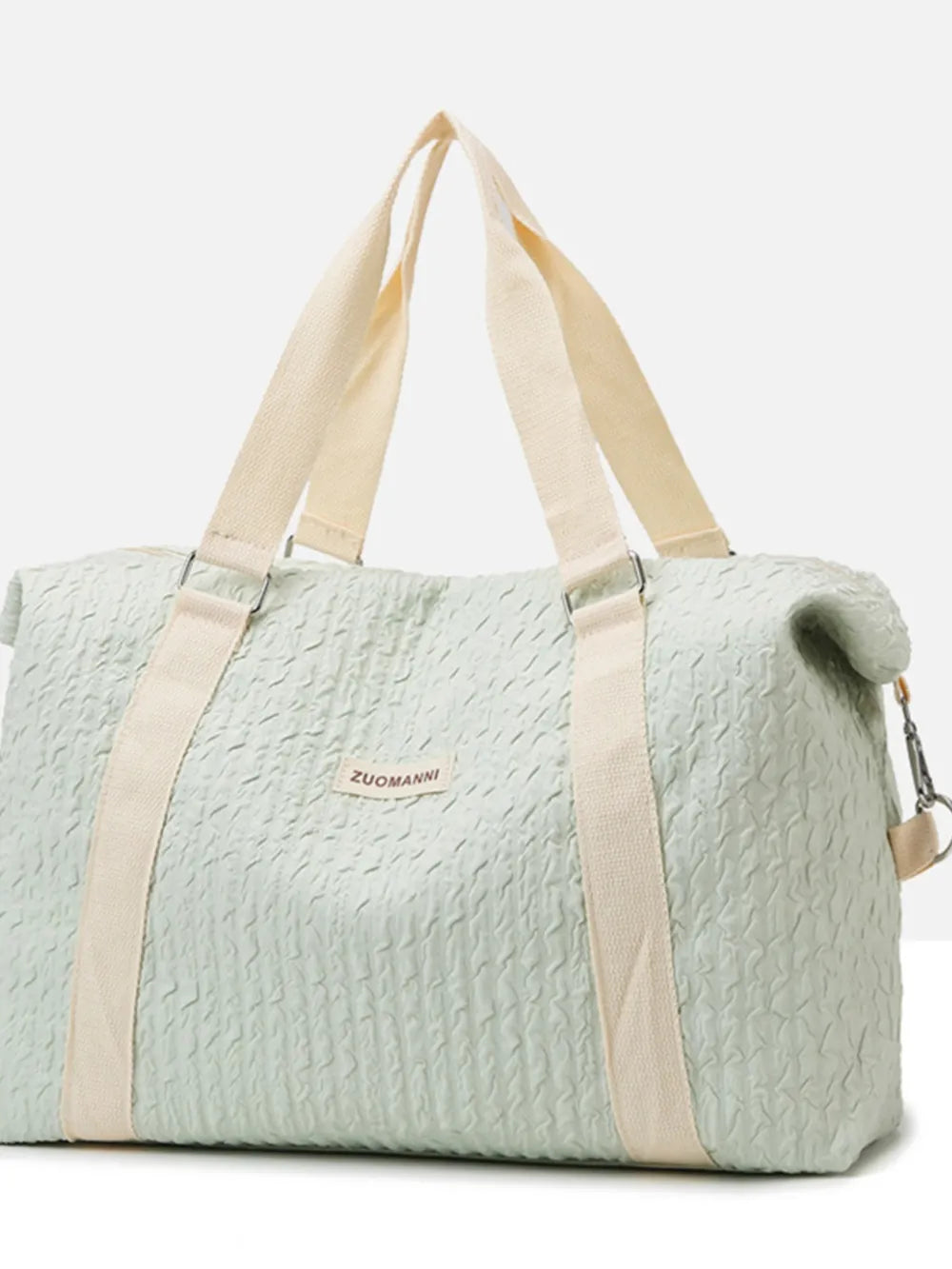 Light  mint green duffel bag with cream-colored handles and shoulder straps, featuring a crinkled texture and a front label. Soft, functional design—ideal for travel, gym, or everyday use.
