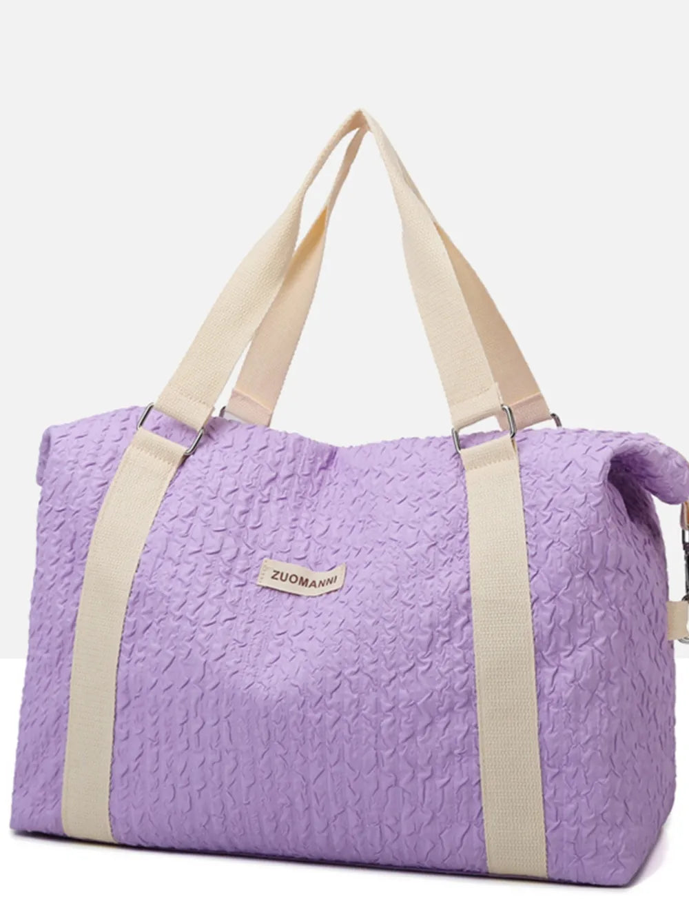 Lavender duffel bag with cream-colored handles and shoulder straps, featuring a crinkled texture and a front label. Soft, functional design—ideal for travel, gym, or everyday use.