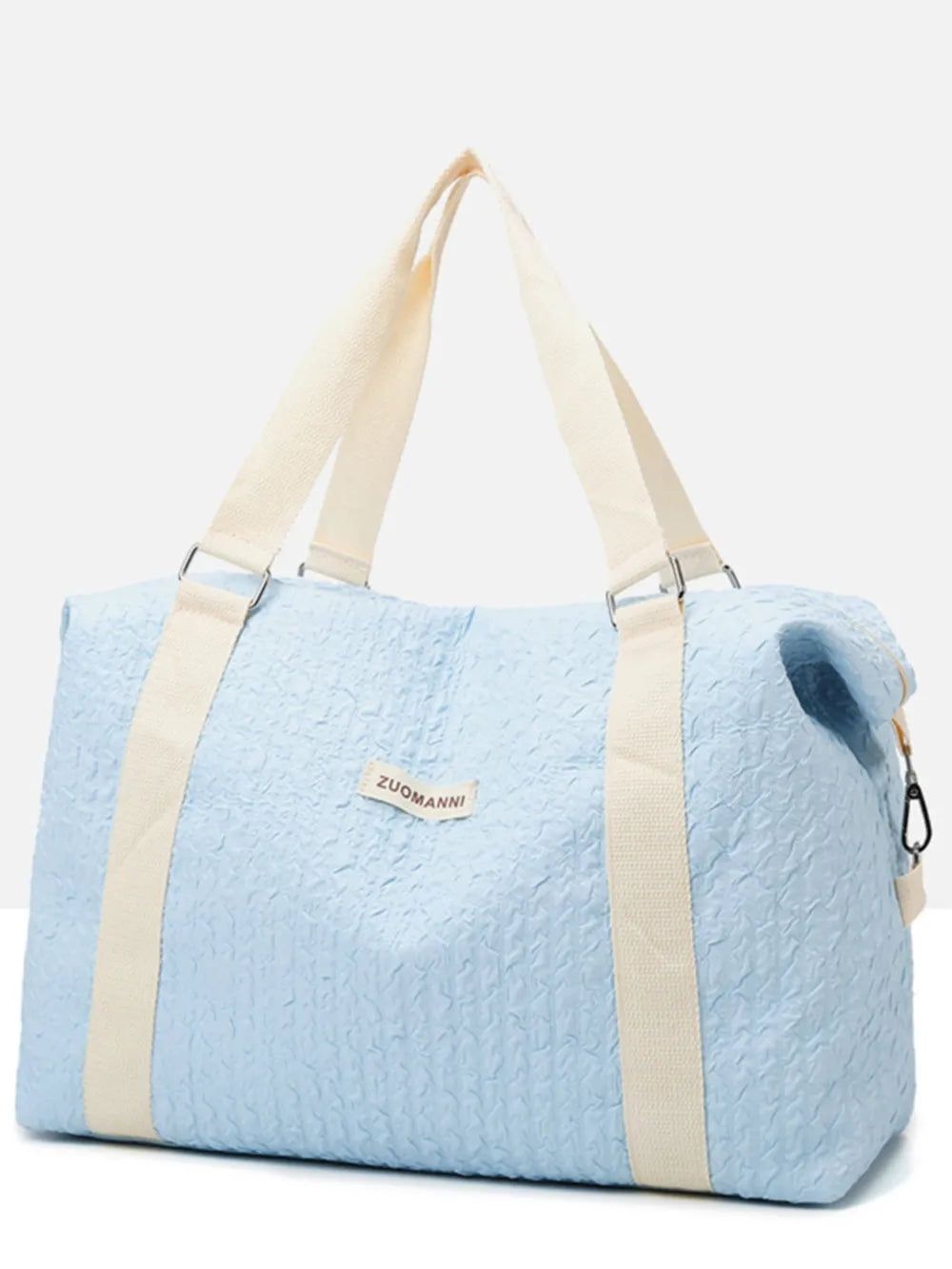 Light blue duffel bag with cream-colored handles and shoulder straps, featuring a crinkled texture and a front label. Soft, functional design—ideal for travel, gym, or everyday use.