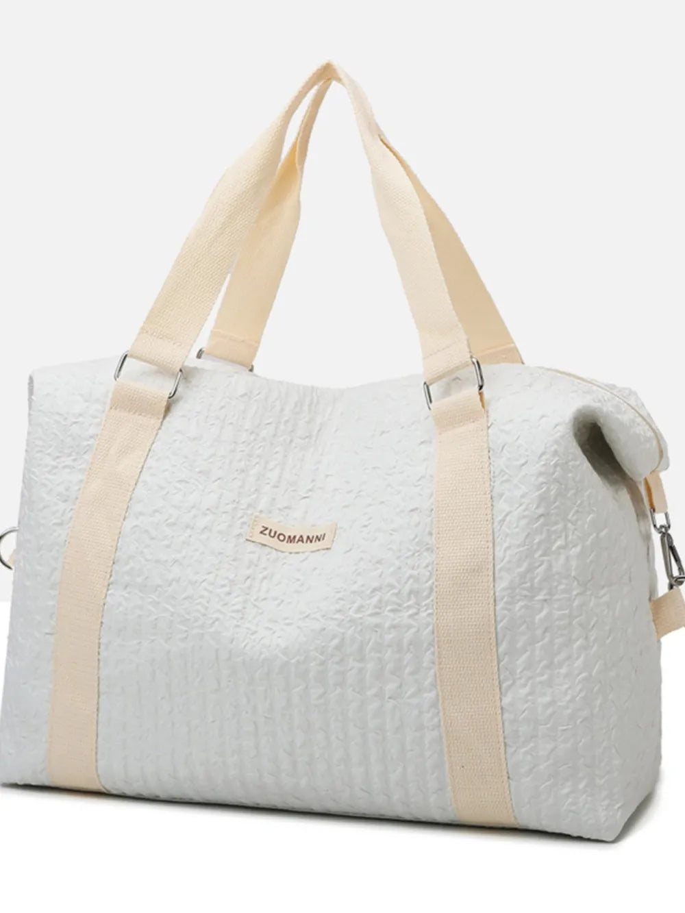 Light gray duffel bag with cream-colored handles and shoulder straps, featuring a crinkled texture and a front label. Soft, functional design—ideal for travel, gym, or everyday use.
