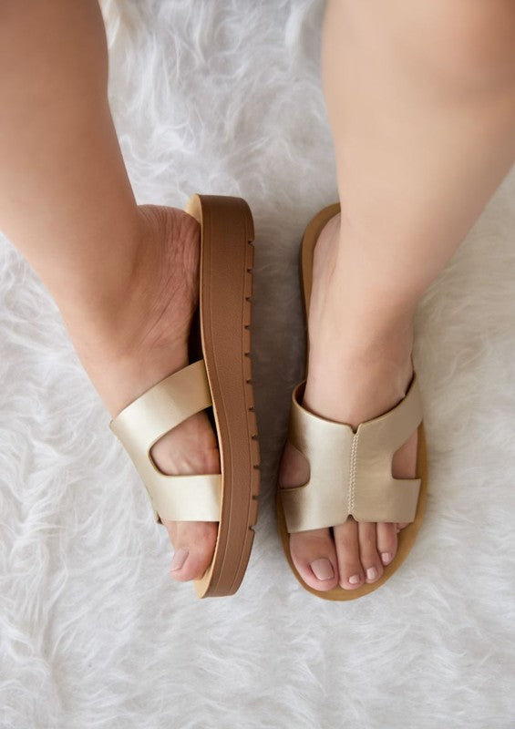 Flatform sandals featuring broad leather upper with side cutouts, open-toe silhouette, and thick textured platform sole