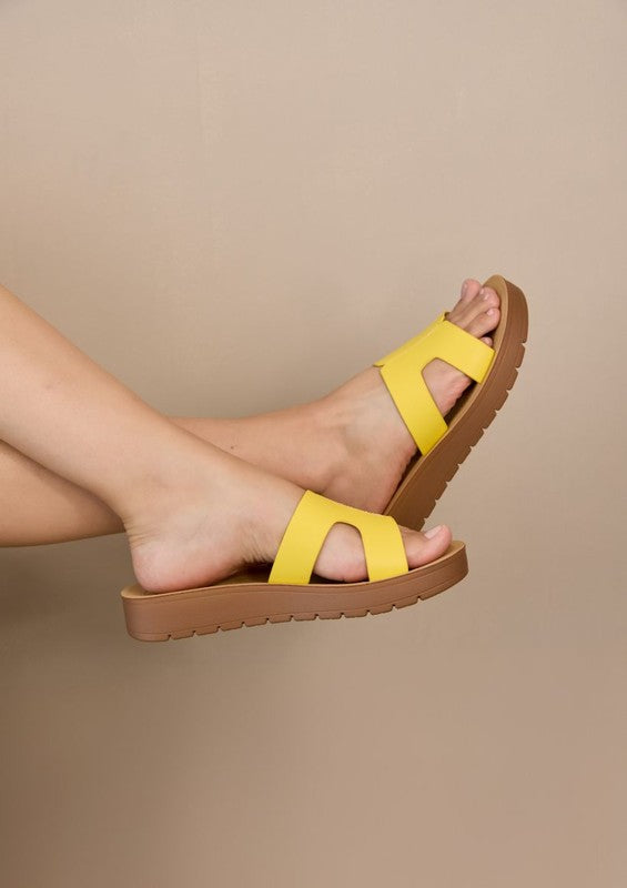 Flatform sandals featuring broad leather upper with side cutouts, open-toe silhouette, and thick textured platform sole