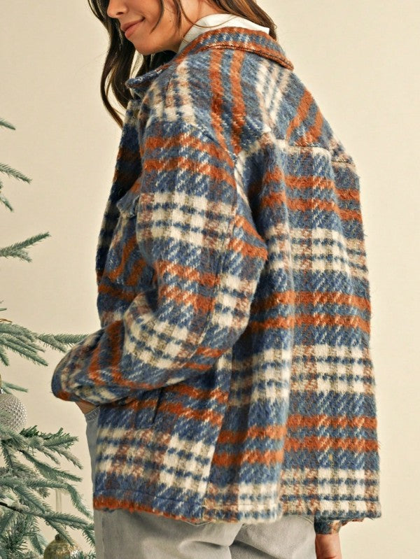 Person wearing a plaid jacket with a neutral background
