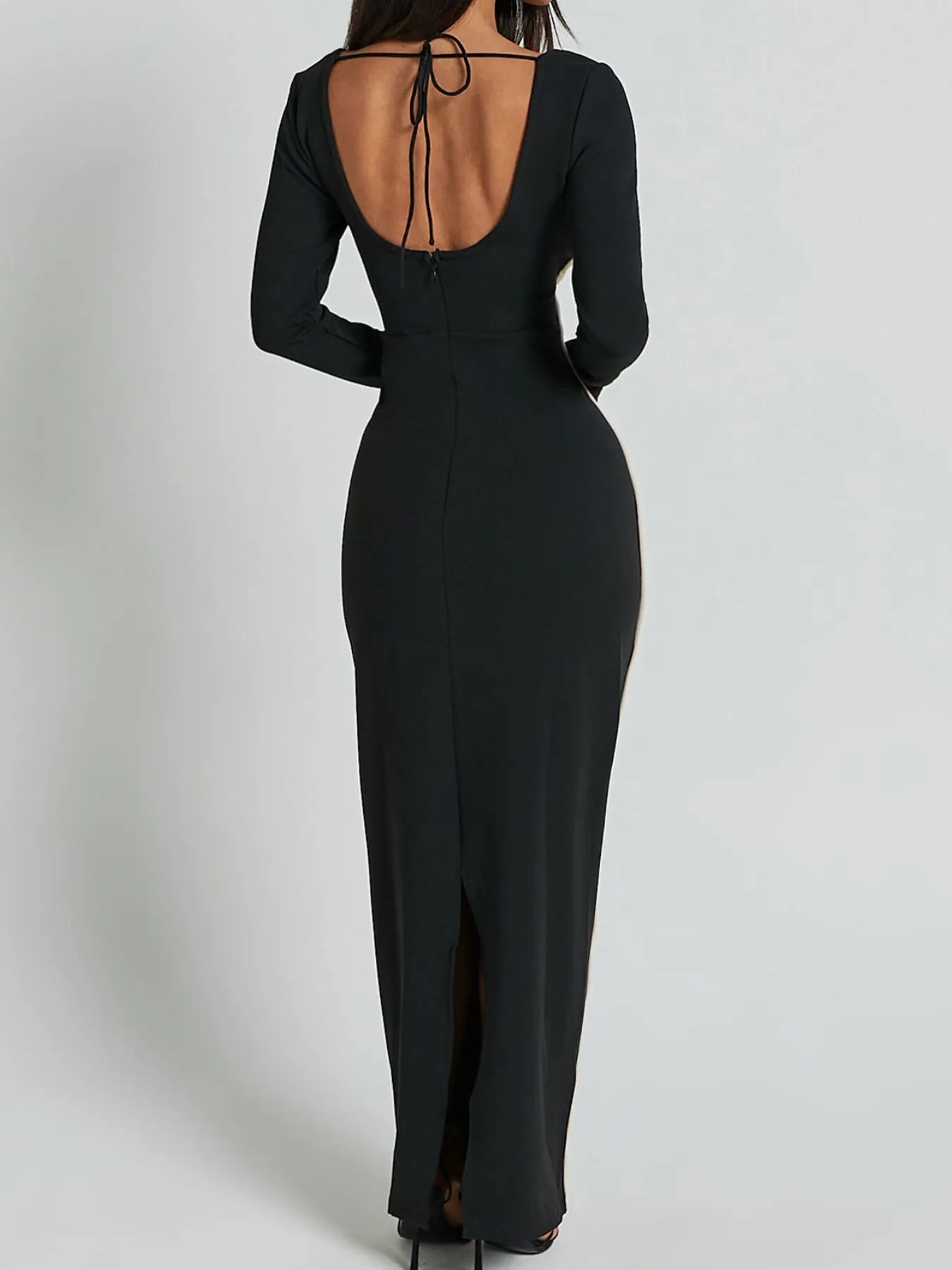 A full length form black dress with long sleeves and white trim details and has a geometric white pattern around the waist and shoulders.