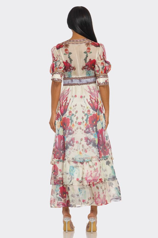 A long, floral maxi with a soft pastel print, a V-neckline, short puff sleeves, a fitted waist, and a ruffled, tiered skirt that falls to the ankles.