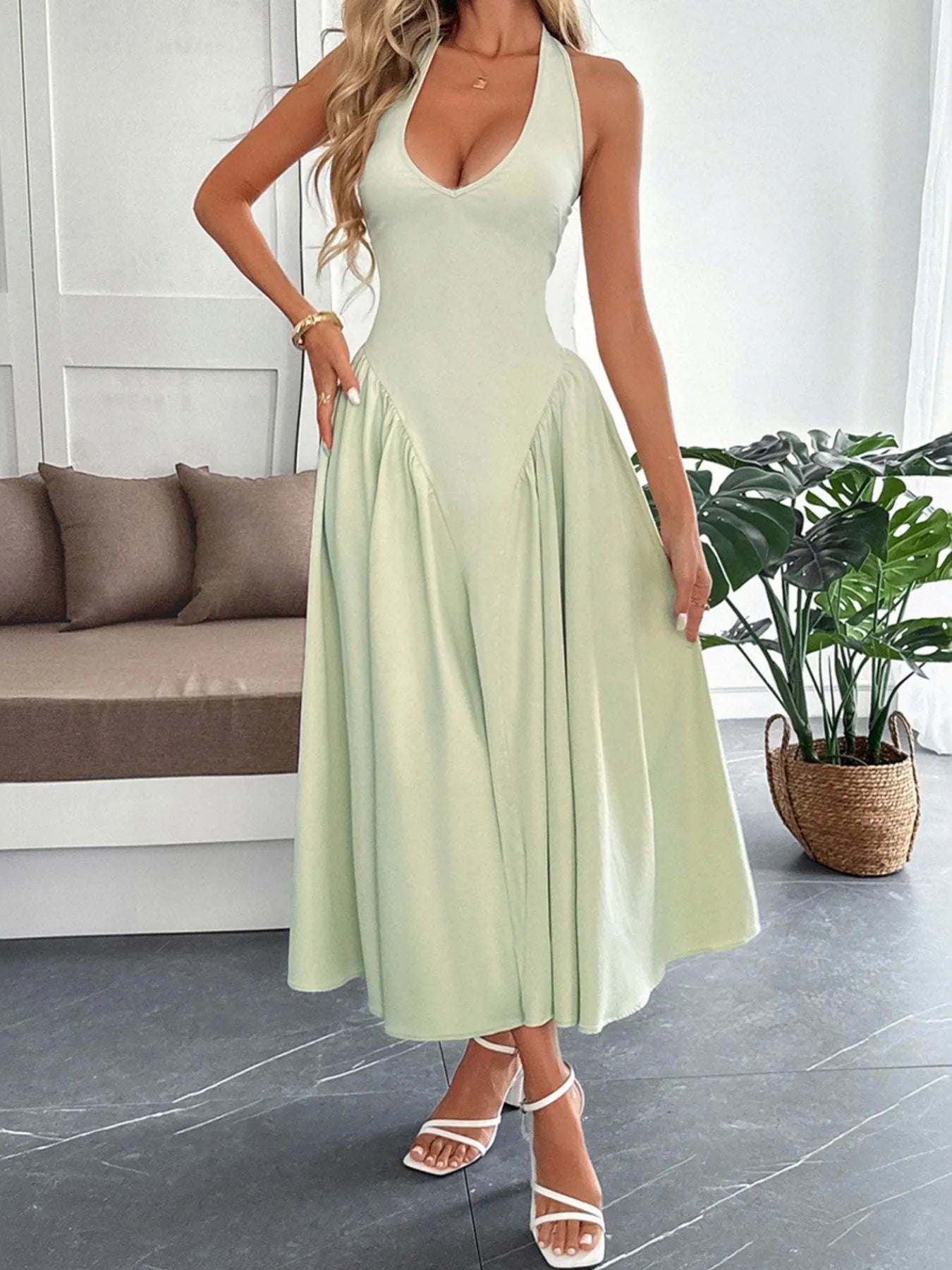 Women's halter neck dress with deep V-neckline and dramatic paneled flare skirt.