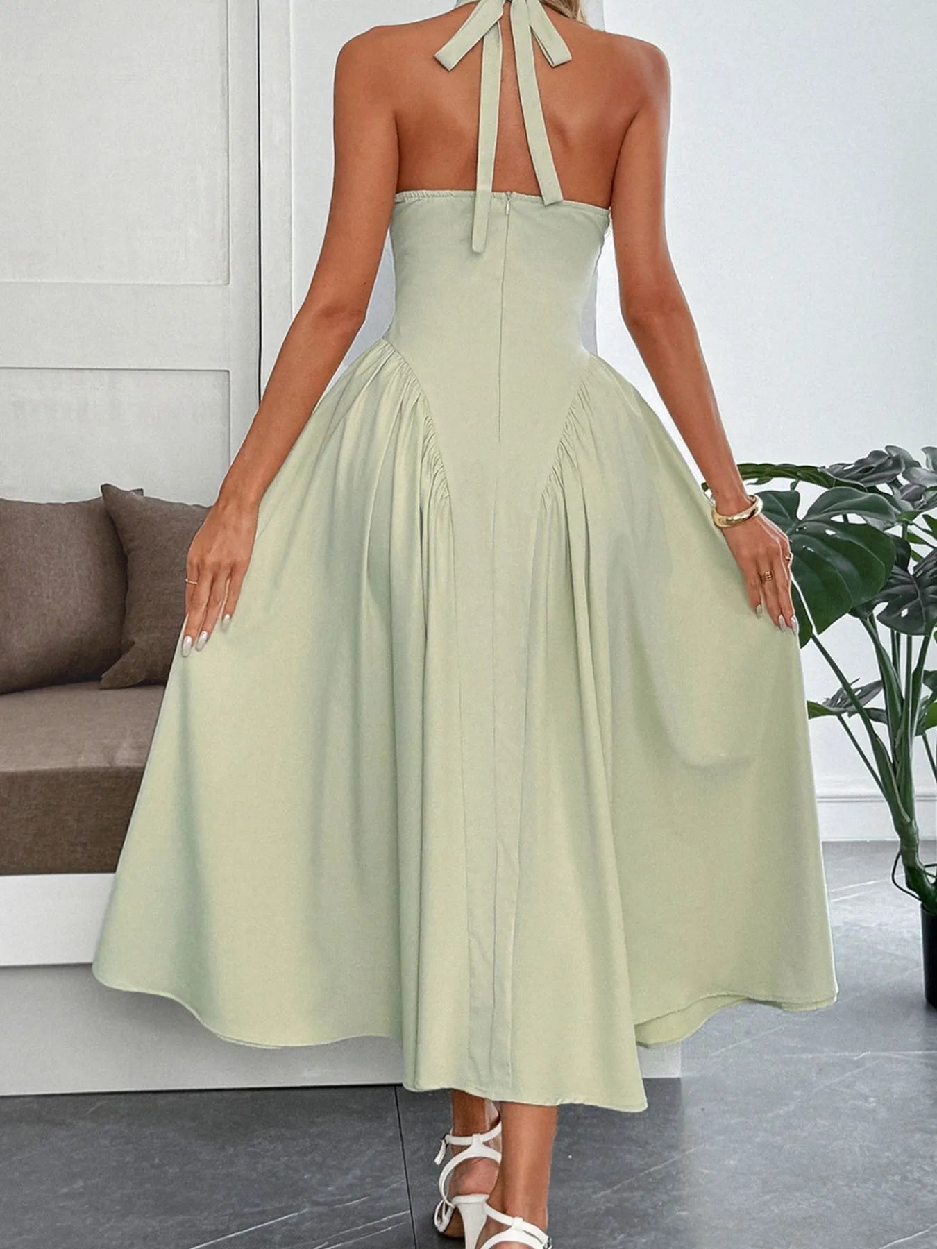 Women's halter neck dress with deep V-neckline and dramatic paneled flare skirt.