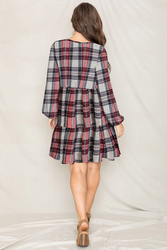 Women's plaid flannel mini dress with tiered skirt, babydoll style, and long balloon sleeves.