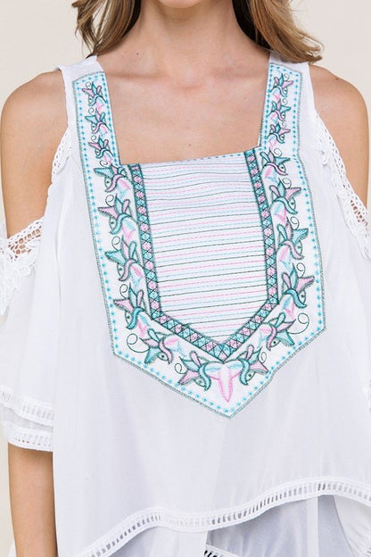 White fashion top with light blue and pink design