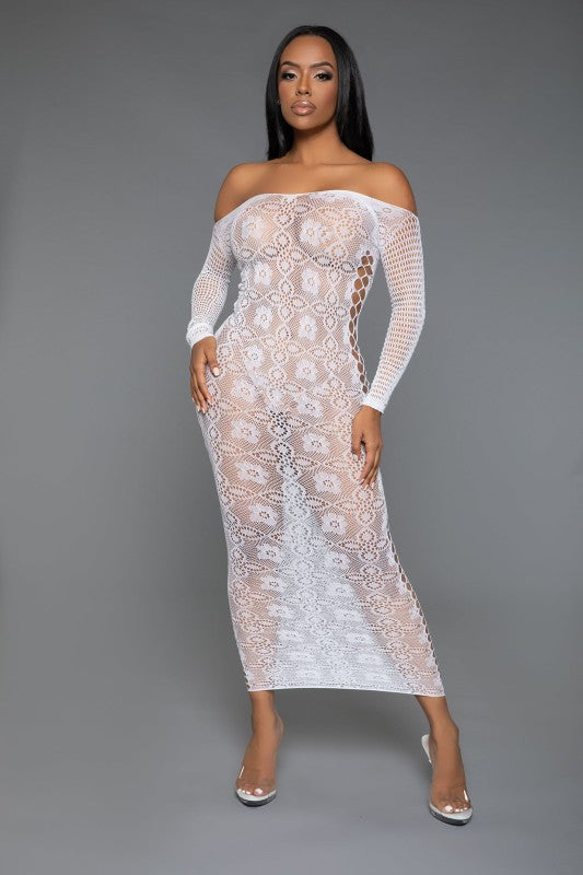 The dress is a form-fitting, full-length white lace bodysuit with long sleeves and a sheer, intricate pattern that reveals the silhouette underneath, paired with open-toe heels for a sultry, elegant look