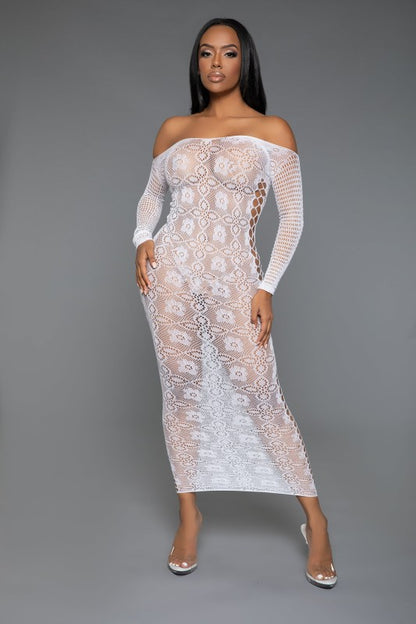 The dress is a form-fitting, full-length white lace bodysuit with long sleeves and a sheer, intricate pattern that reveals the silhouette underneath, paired with open-toe heels for a sultry, elegant look
