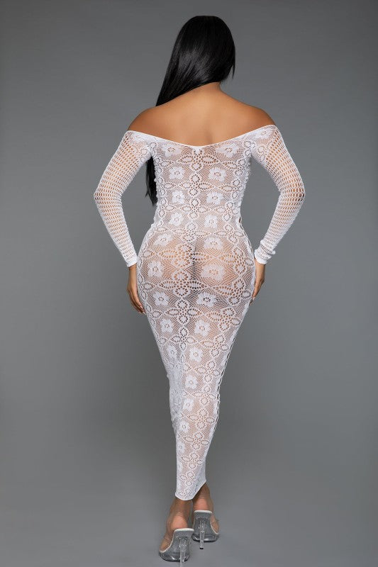 The dress is a form-fitting, full-length white lace bodysuit with long sleeves and a sheer, intricate pattern that reveals the silhouette underneath, paired with open-toe heels for a sultry, elegant look