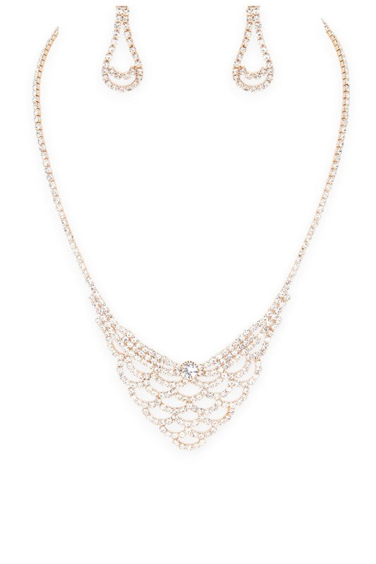 Elegant jewelry set featuring a necklace, teardrop earrings, and bracelet with intricate looped designs and a central gemstone, perfect for formal occasions or gifting.