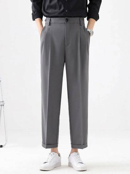 Person wearing gray pants and a black shirt on a white background