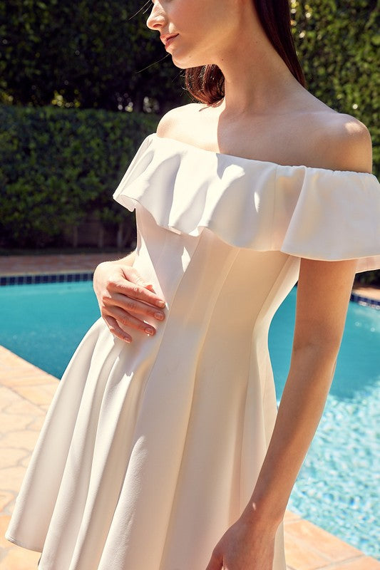 The dress is a short, off-the-shoulder white frock with a dramatic ruffled neckline and a flared, A-line skirt.