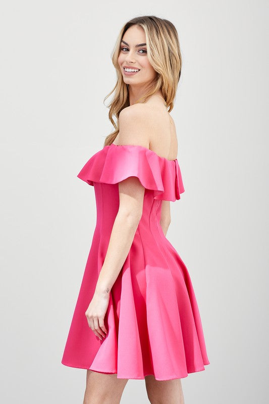 The dress is a short, off-the-shoulder pink frock with a dramatic ruffled neckline and a flared, A-line skirt.