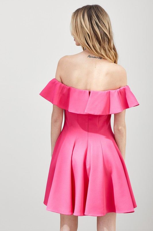 The dress is a short, off-the-shoulder pink frock with a dramatic ruffled neckline and a flared, A-line skirt.