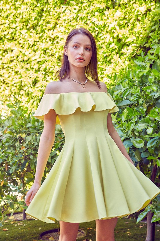the dress is a short, off-the-shoulder pink frock with a dramatic ruffled neckline and a flared, A-line skirt