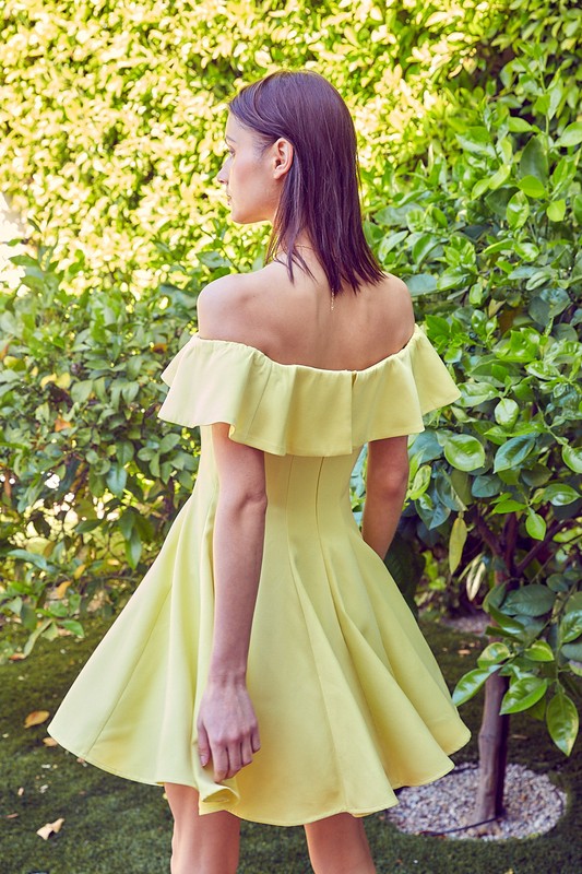 the dress is a short, off-the-shoulder light green frock with a dramatic ruffled neckline and a flared, A-line skirt