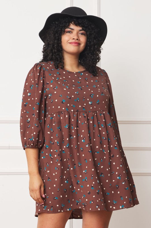 The dress is a short, loose-fitting black shift adorned with a delicate, colorful floral print and three-quarter sleeves