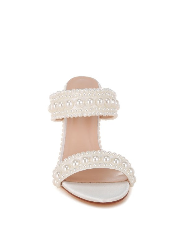 White sandal with pearl embellishments on a white background