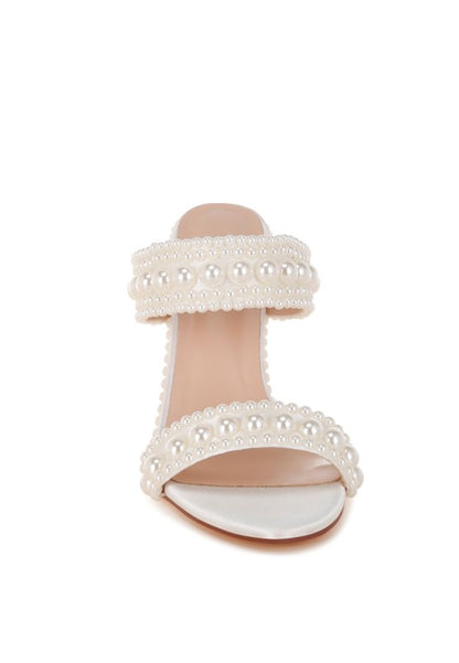 White sandal with pearl embellishments on a white background
