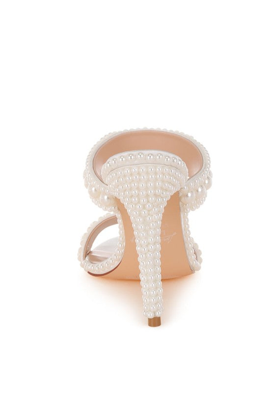 High-heeled shoe with pearl detailing on a white background