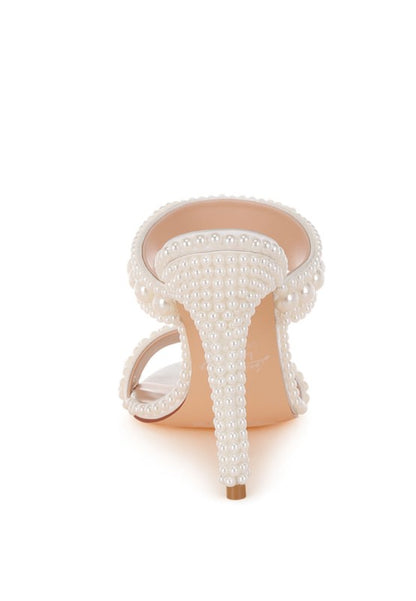 High-heeled shoe with pearl detailing on a white background