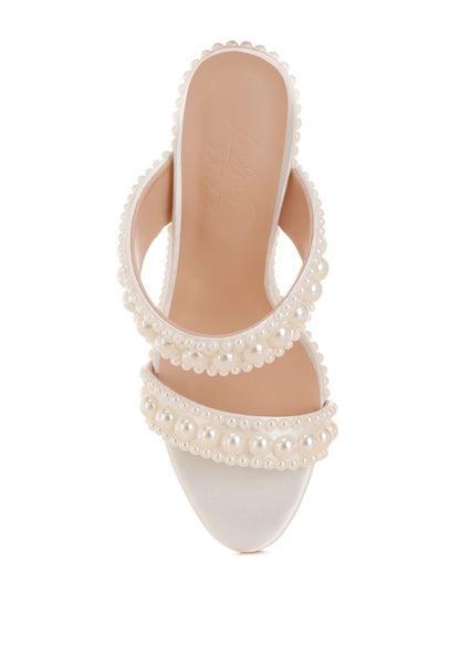 White sandal with pearl embellishments on a white background