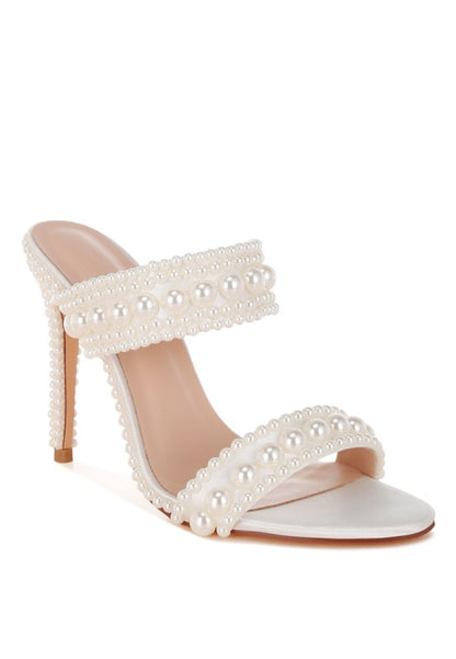 White high-heeled sandal with pearl embellishments on a white background
