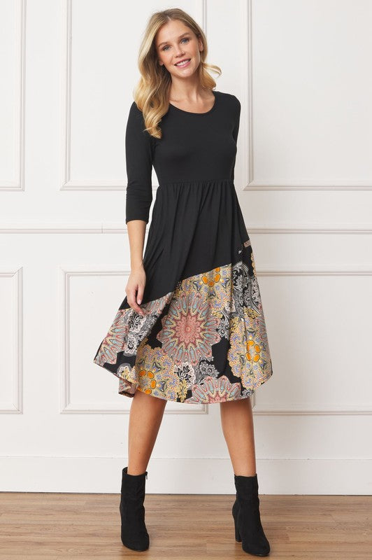 Woman wears a stylish asymmetrical midi dress with a bohemian-inspired pattern, perfect for a unique and trendy look, front view.