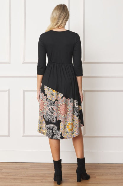 Woman wears a stylish asymmetrical midi dress with a bohemian-inspired pattern, perfect for a unique and trendy look, back view.