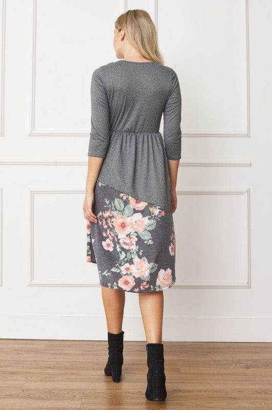 Woman wearing a gray midi dress with a floral pattern on the bottom half, back view.