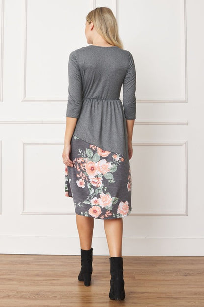 Woman wearing a gray midi dress with a floral pattern on the bottom half, back view.