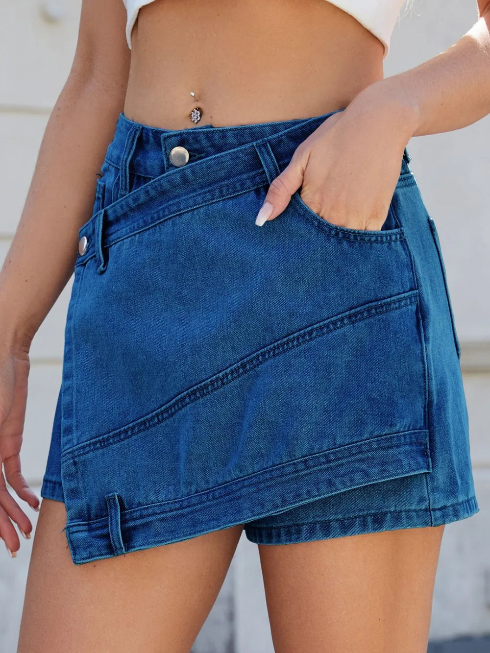 Blue denim skirt worn by a person with a neutral background
