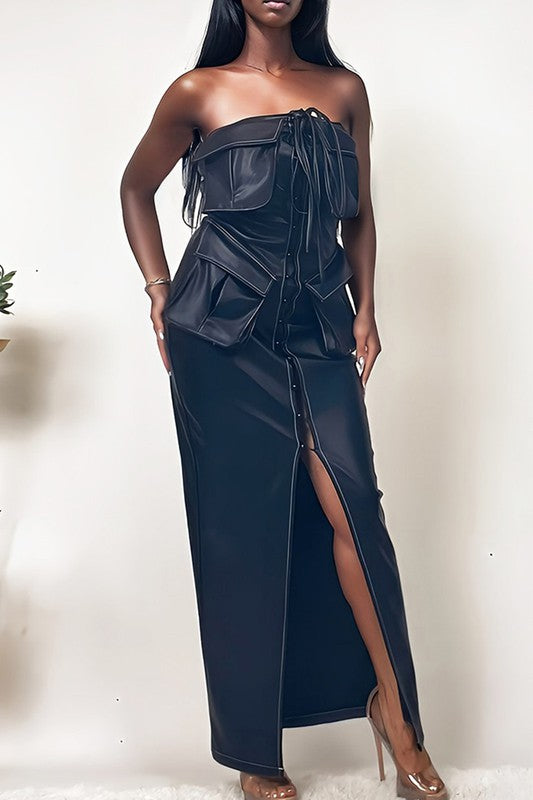 The dress is a sleek, off-shoulder, dark navy gown with a structured bodice, a dramatic draped overlay, and a high slit that reveals one leg.