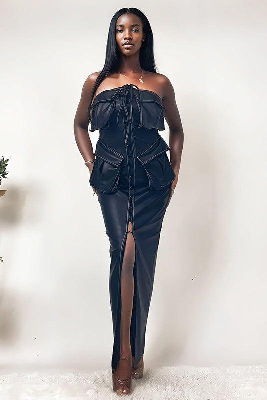 The dress is a sleek, off-shoulder, dark navy gown with a structured bodice, a dramatic draped overlay, and a high slit that reveals one leg.