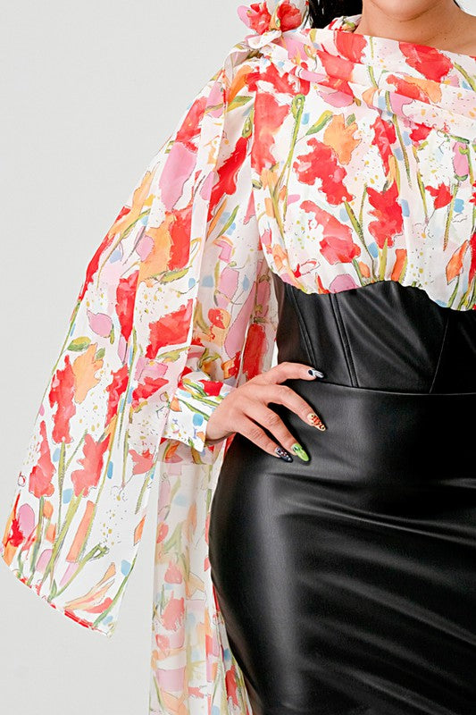 a woman in a black leather mini skirt and a floral print off-the-shoulder top with dramatic sleeves.