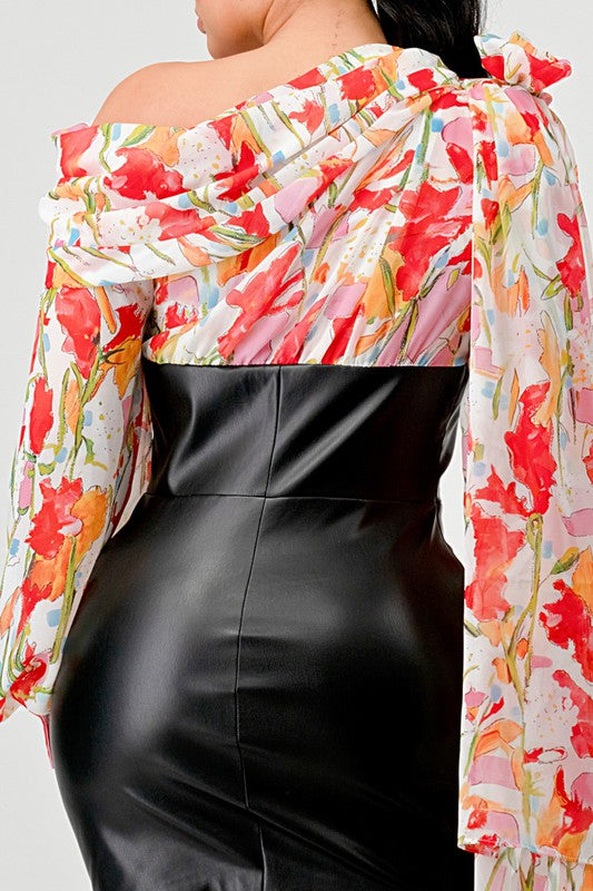 a woman in a black leather mini skirt and a floral print off-the-shoulder top with dramatic sleeves.