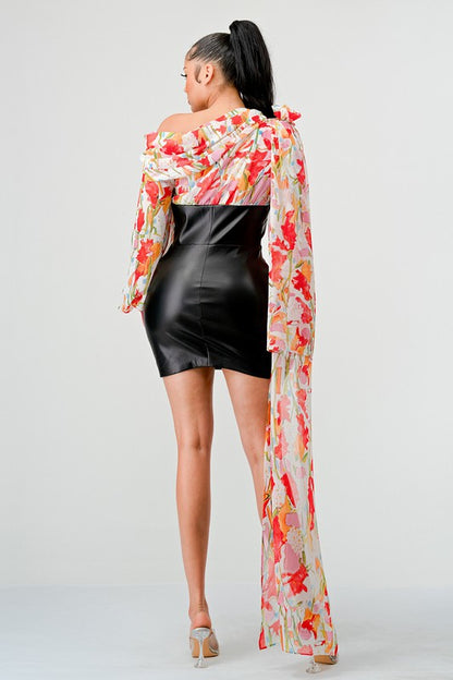 a woman in a black leather mini skirt and a floral print off-the-shoulder top with dramatic sleeves.