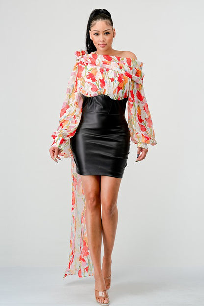 a woman in a black leather mini skirt and a floral print off-the-shoulder top with dramatic sleeves.