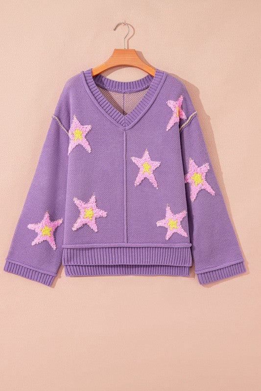 Oversized purple V-neck sweater, featuring pink and yellow star patches and unique seam details, front view.