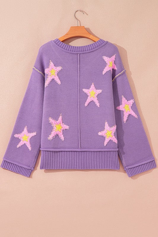 Oversized purple V-neck sweater, featuring pink and yellow star patches and unique seam details, back view.