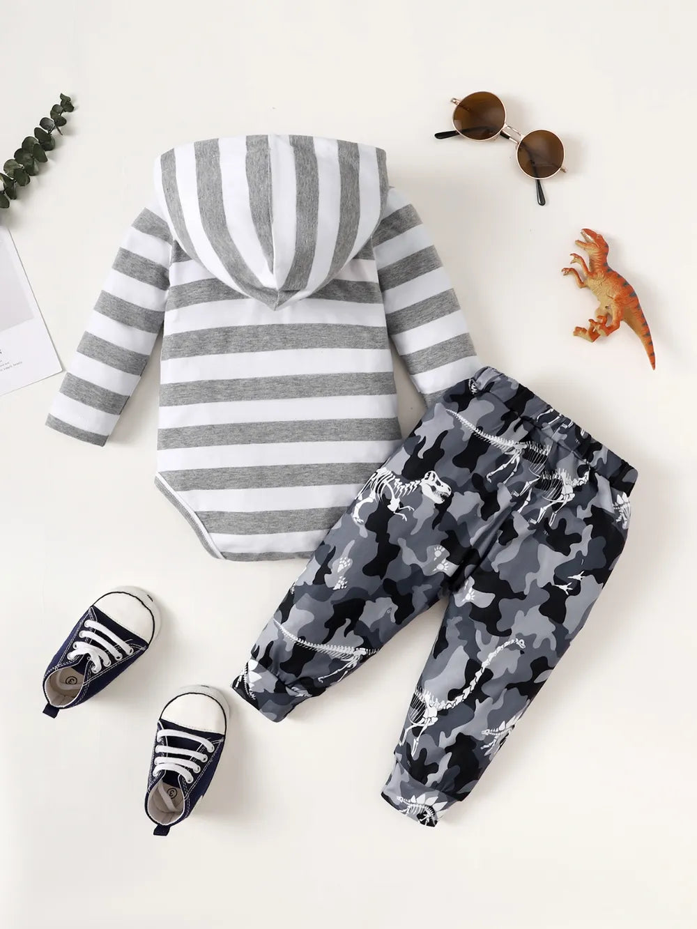 Children's outfit with striped hoodie and camouflage pants on a white background