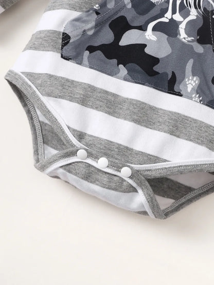 Gray and black camouflage dog coat with white trim on a light background