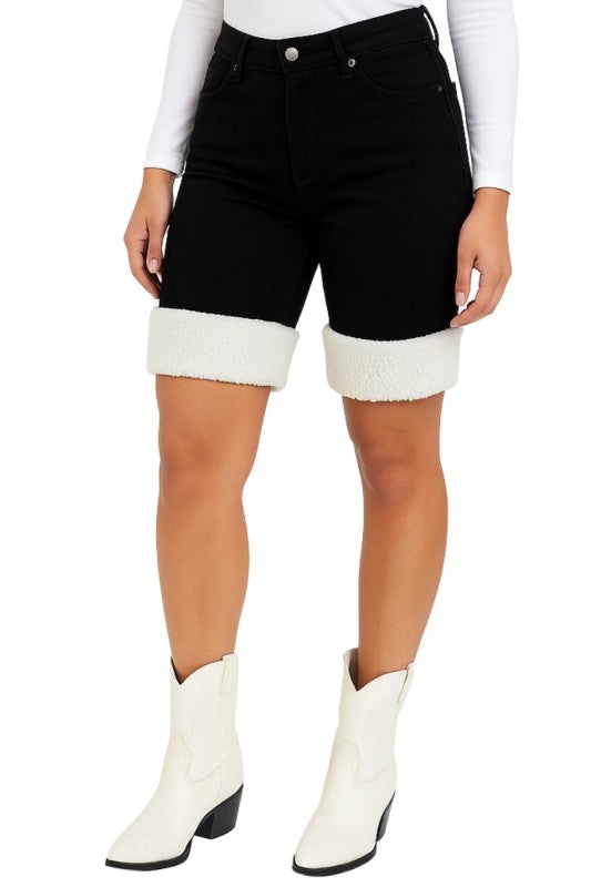 Bold denim meets cozy detail. These black denim capri shorts are designed to turn heads with their unique sherpa-trimmed cuffs and sleek silhouette. Whether you're headed to a rodeo, concert, or just want to elevate your everyday look, these shorts deliver standout style with comfort built in.