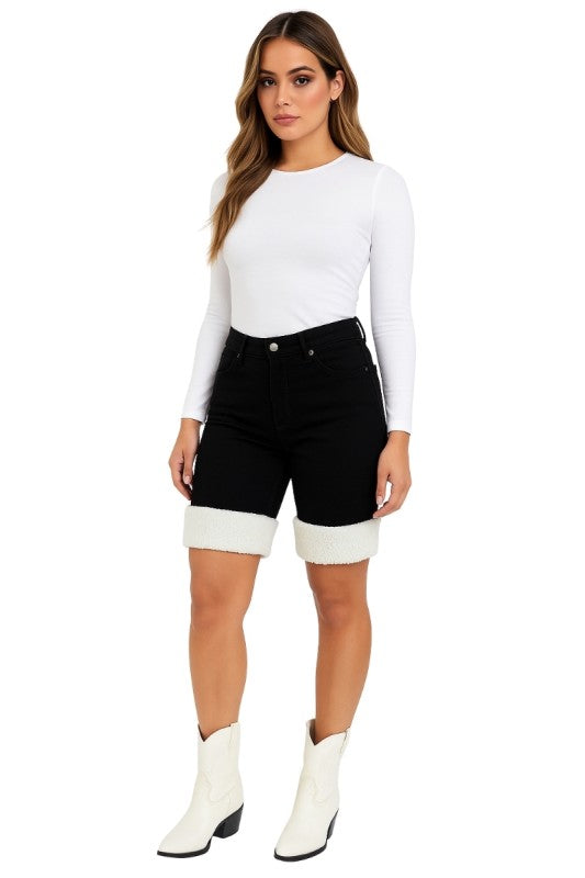 Bold denim meets cozy detail. These black denim capri shorts are designed to turn heads with their unique sherpa-trimmed cuffs and sleek silhouette. Whether you're headed to a rodeo, concert, or just want to elevate your everyday look, these shorts deliver standout style with comfort built in.