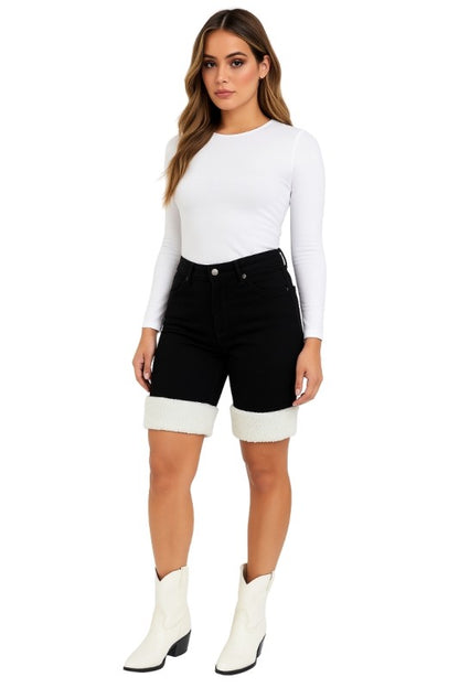 Bold denim meets cozy detail. These black denim capri shorts are designed to turn heads with their unique sherpa-trimmed cuffs and sleek silhouette. Whether you're headed to a rodeo, concert, or just want to elevate your everyday look, these shorts deliver standout style with comfort built in.